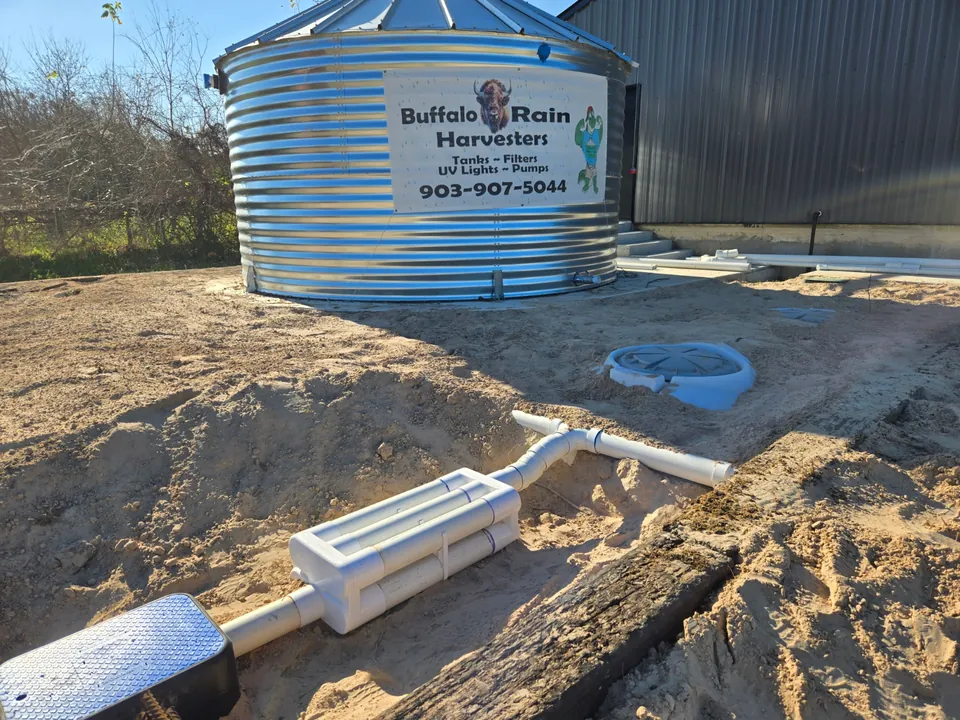 Rainwater treatment system beside a metal tank